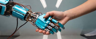 a robot hand shaking a human hand