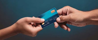 Two human hands exchanging a blue credit card